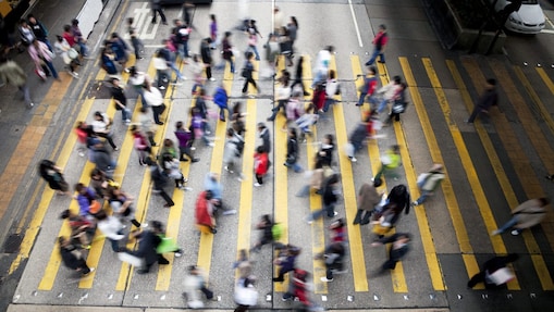 Hong Kong'da işlek bir caddeden karşıya geçen insanlar