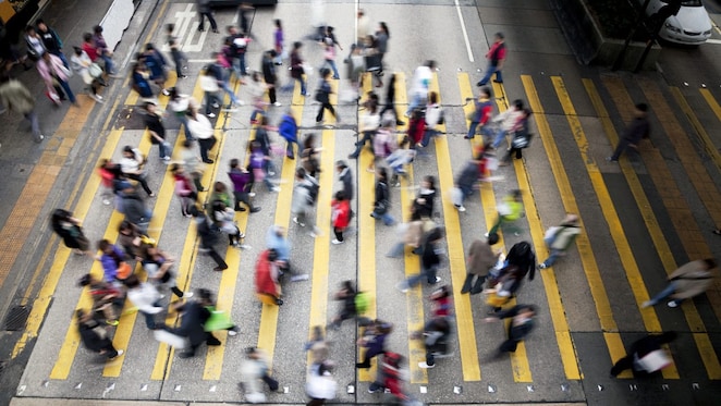 Hong Kong'da işlek bir caddeden karşıya geçen insanlar