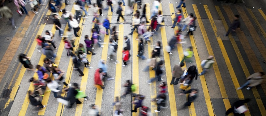 Hong Kong'da işlek bir caddeden karşıya geçen insanlar