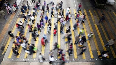Hong Kong'da işlek bir caddeden karşıya geçen insanlar