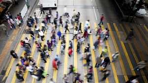 Hong Kong'da işlek bir caddeden karşıya geçen insanlar