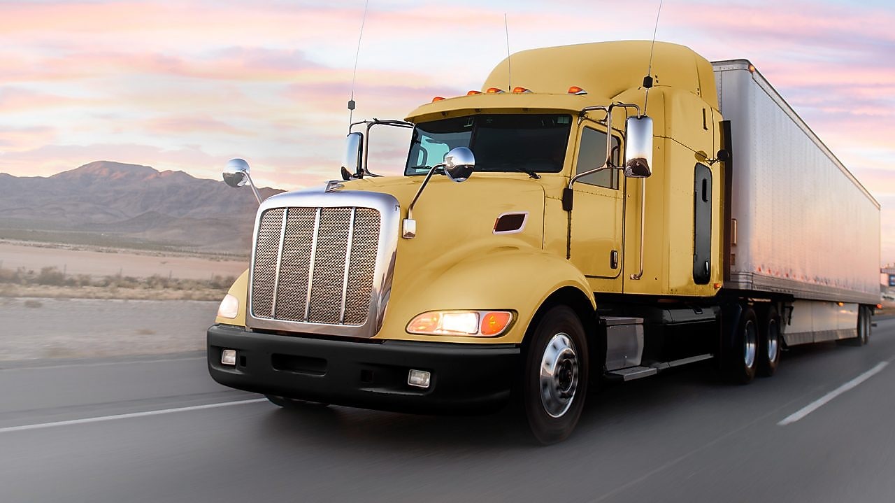 gün batımında yolda giden sarı tır