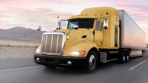 gün batımında yolda giden sarı tır