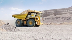 çakıllı zeminde ilerleyen damperli sarı kamyon