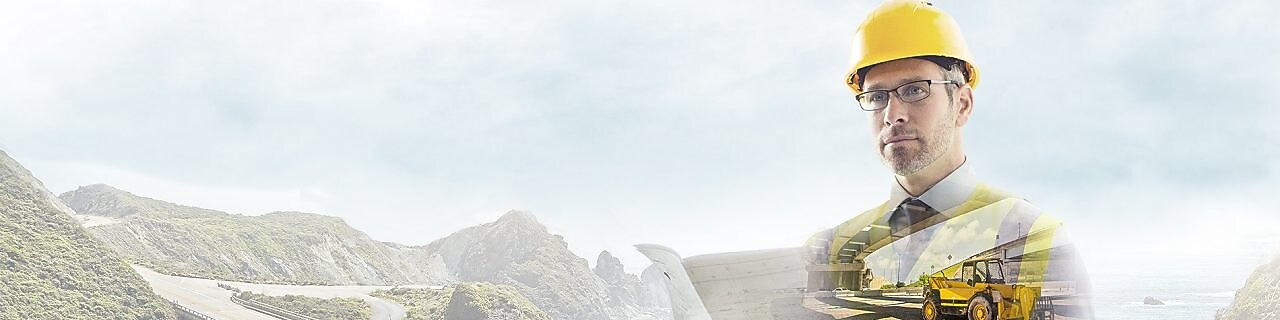 Dağların arasındaki bir yol arka fonunun önünde sarı baretli işçi