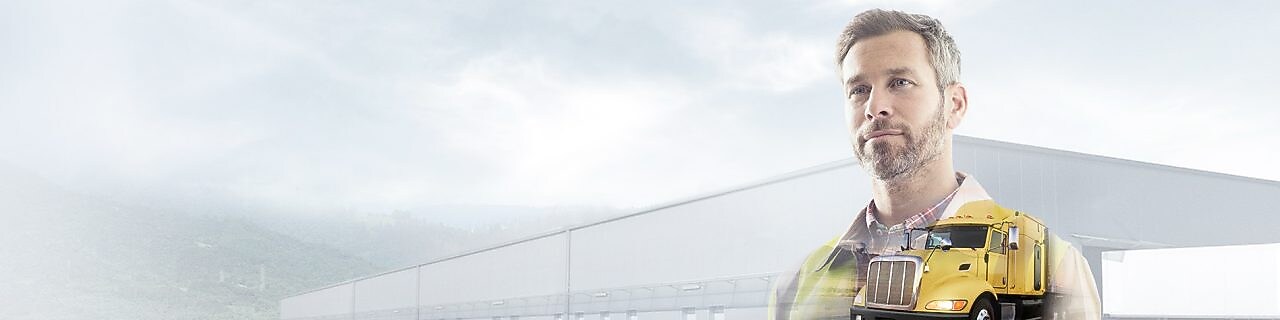 işyerinde sarı bir tırın önünde döküman okuyan adam