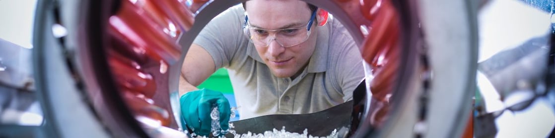 Plastik paletleri kepçeyle karıştırma makinesine koyan adam
