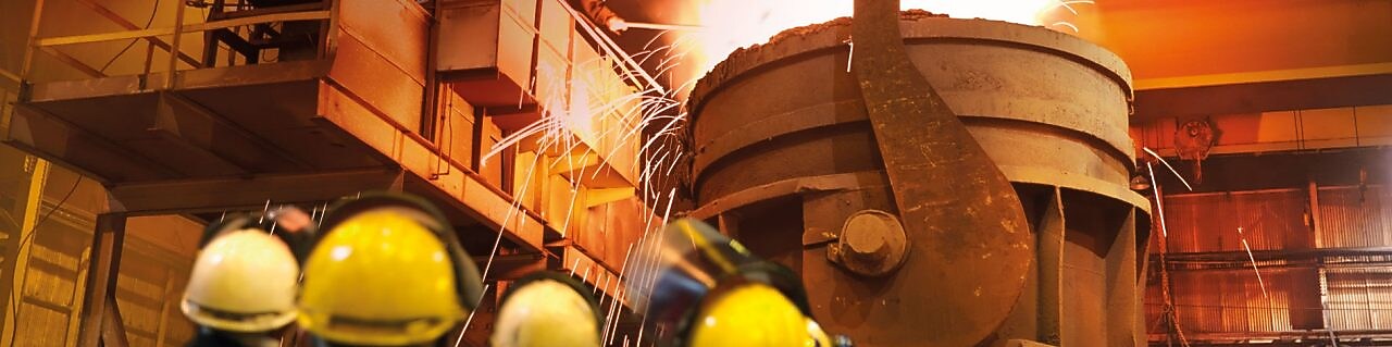 metal işleyen bir işletmede ağır iş makinelerini izleyen işçiler