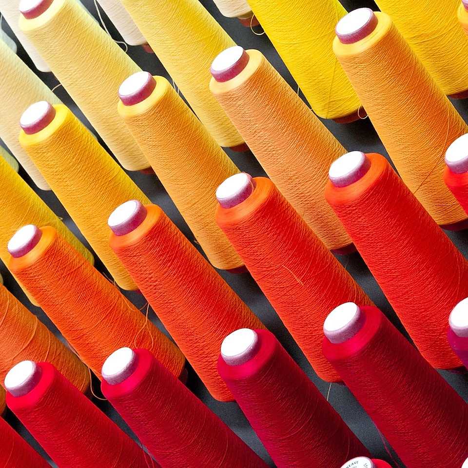 Farklı renkte pamuk iplikler taşıyan çoklu bobinler