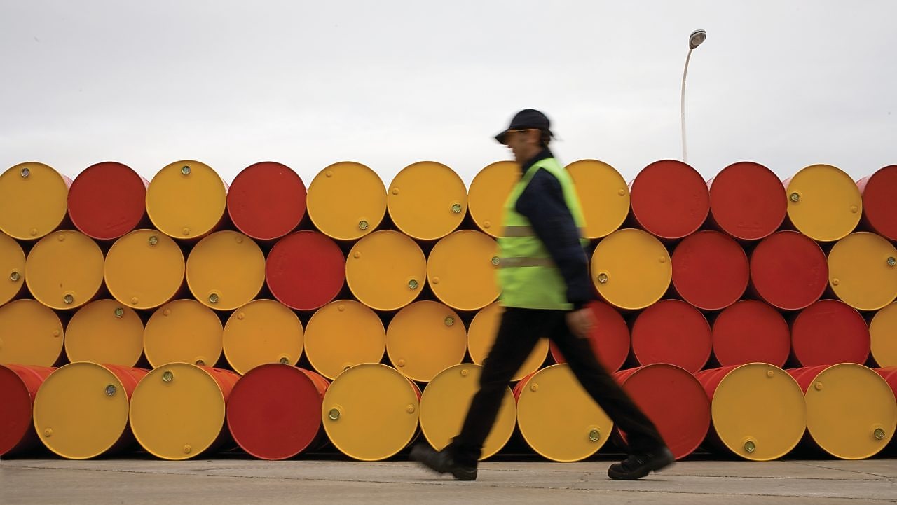 yağlayıcı varillerinin önünde yürüyen adam