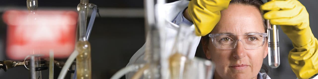 Laboratuvar deneyi yapan koruyucu gözlüklü bayan