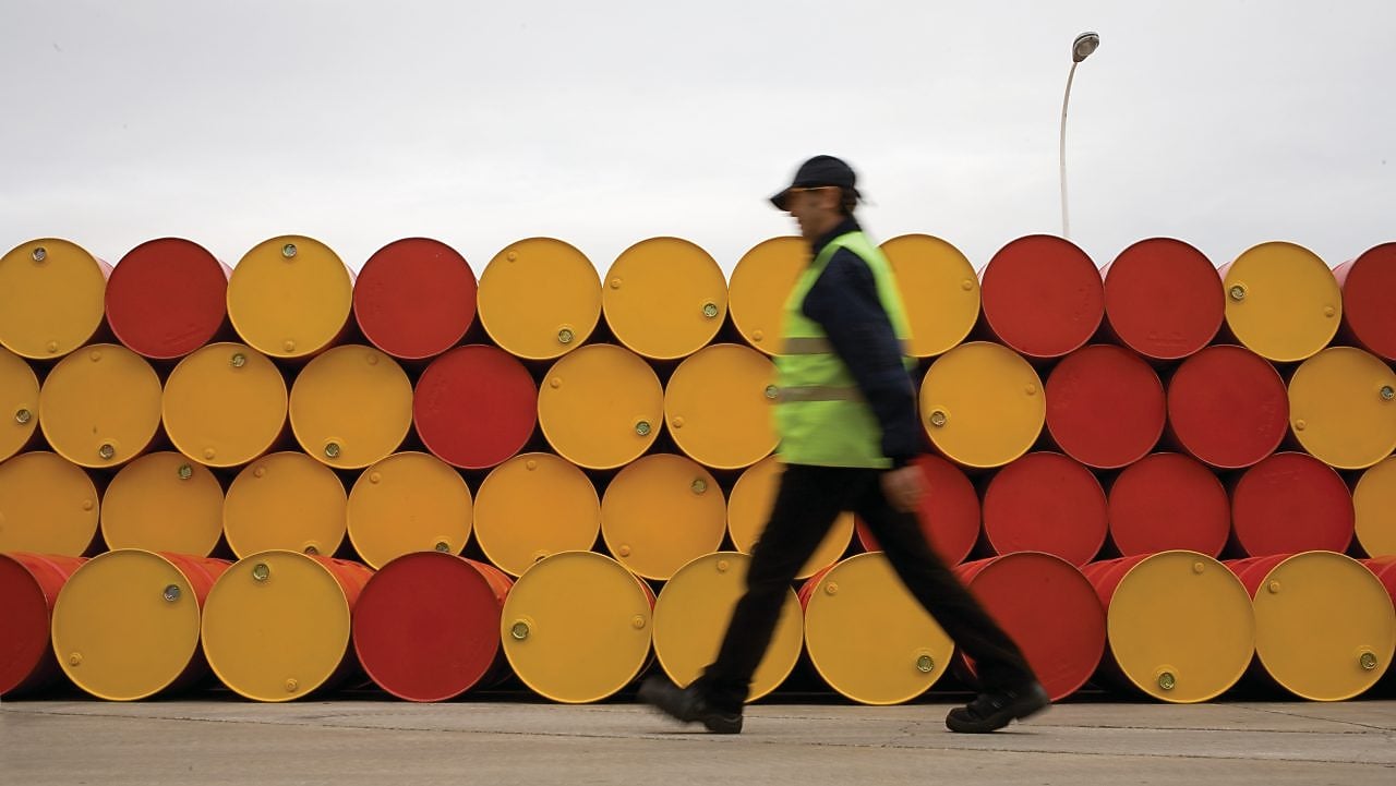 yağlayıcı varillerinin önünde yürüyen adam