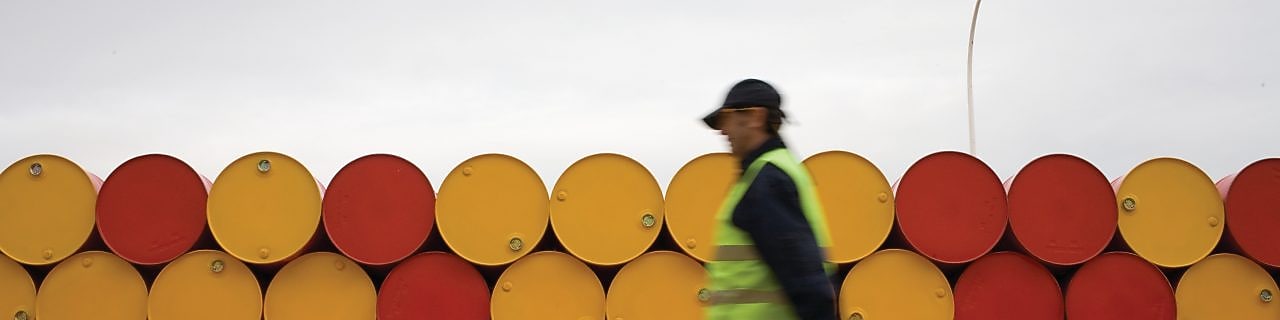 yağlayıcı varillerinin önünde yürüyen adam