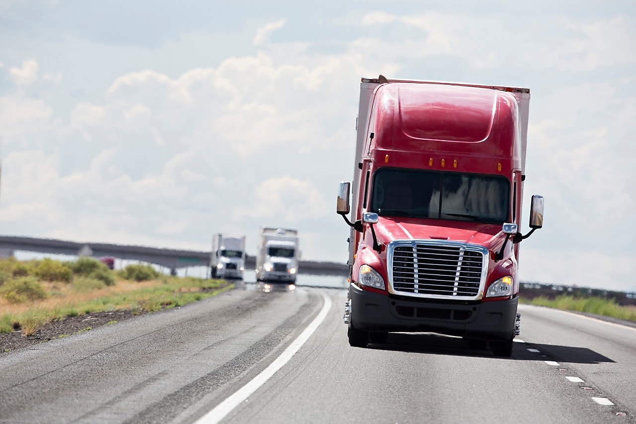 Red and white trucks on the road