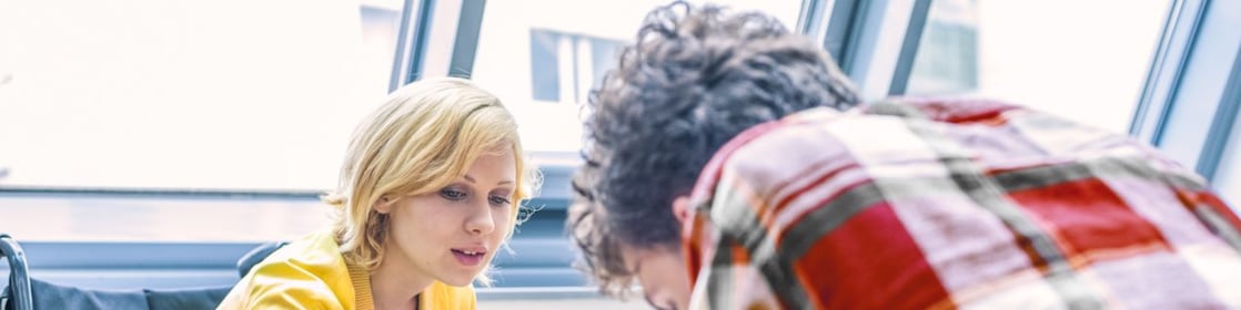 Tekerlekli sandalyeli bir kadın bir erkekle konuşuyor