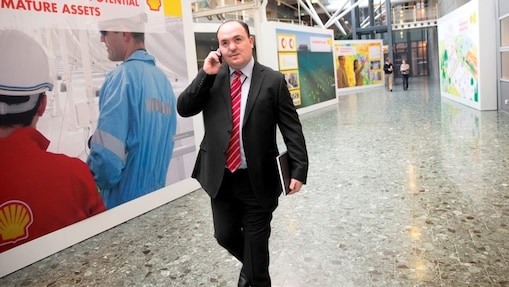Andy Kneen bir Shell ofisinde yürürken telefonda konuşuyor