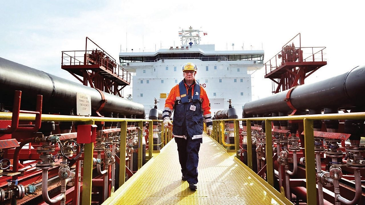 Shell gemisinin etrafında yürüyen işçi