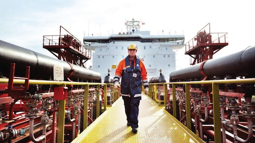 Shell gemisinin etrafında yürüyen işçi