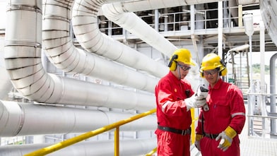 İki mühendis ellerindeki ekipmana bakıyor