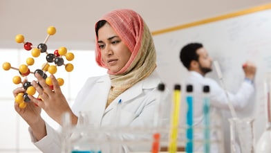 Genç bir bayan bilim insanı moleküler bir modeli inceliyor