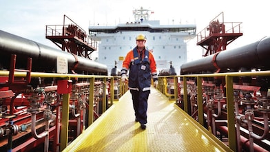 Shell gemisinin etrafında yürüyen işçi