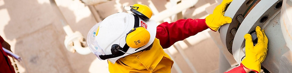 Güvenlik maskesi ve eldiven takan işçi 