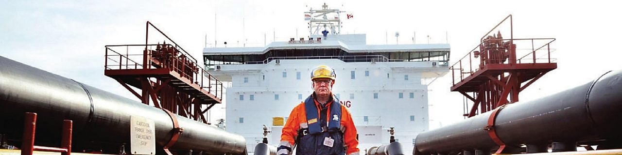 Shell gemisinin etrafında yürüyen işçi