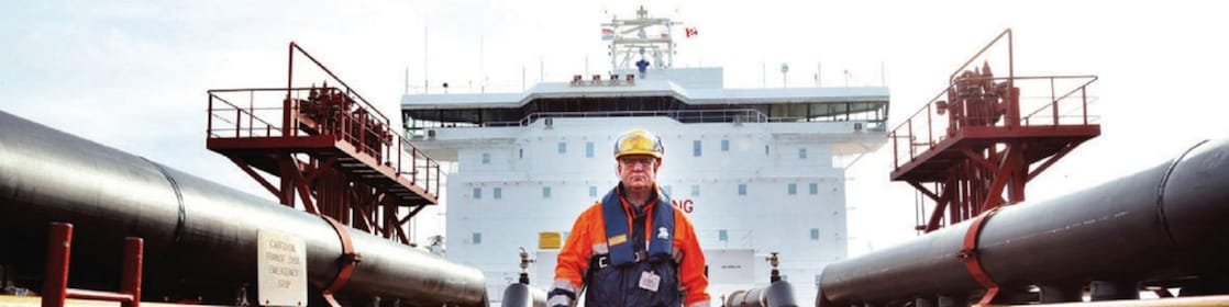 Shell gemisinin etrafında yürüyen işçi