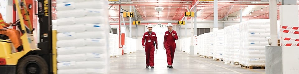 Bir fabrikada yürüyüş yapan iki çalışan