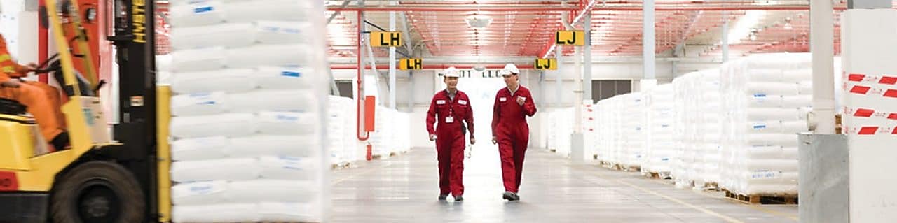 Bir fabrikada yürüyüş yapan iki çalışan