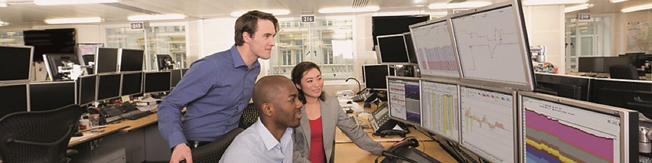 Verileri çoklu bilgisayar ekranlarından inceleyen Ticaret personeli