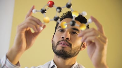 Moleküler modeli inceleyen genç bir adam