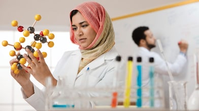 Genç bir bayan bilim insanı moleküler bir modeli inceliyor