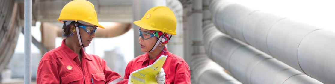 Malezya'da bir rafineride iki işçi bir projeyi tartışıyorlar