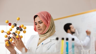 Genç bir bayan bilim insanı moleküler bir modeli inceliyor