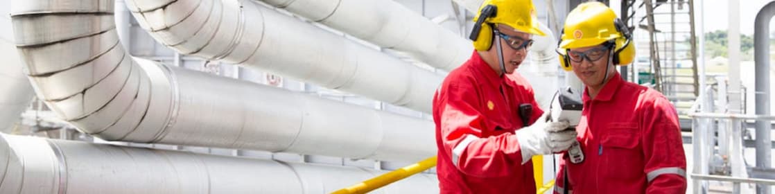 İki mühendis ellerindeki ekipmana bakıyor