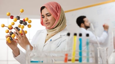 Genç bir bayan bilim insanı moleküler bir modeli inceliyor