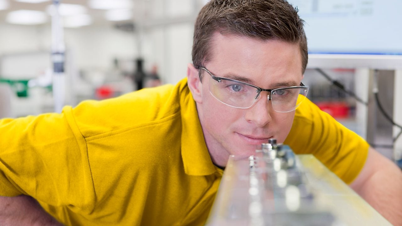 Laboratuarda bir cihaza bakan adam