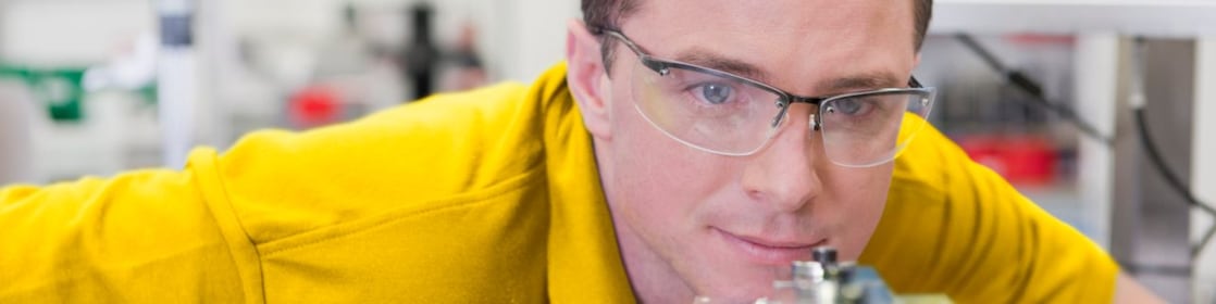 Laboratuarda bir cihaza bakan adam