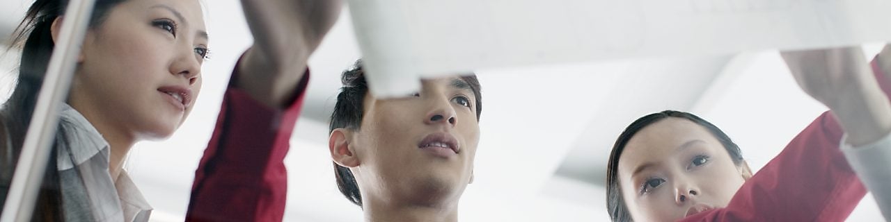 İşteyken tasarım planlarını tartışan mezunlar