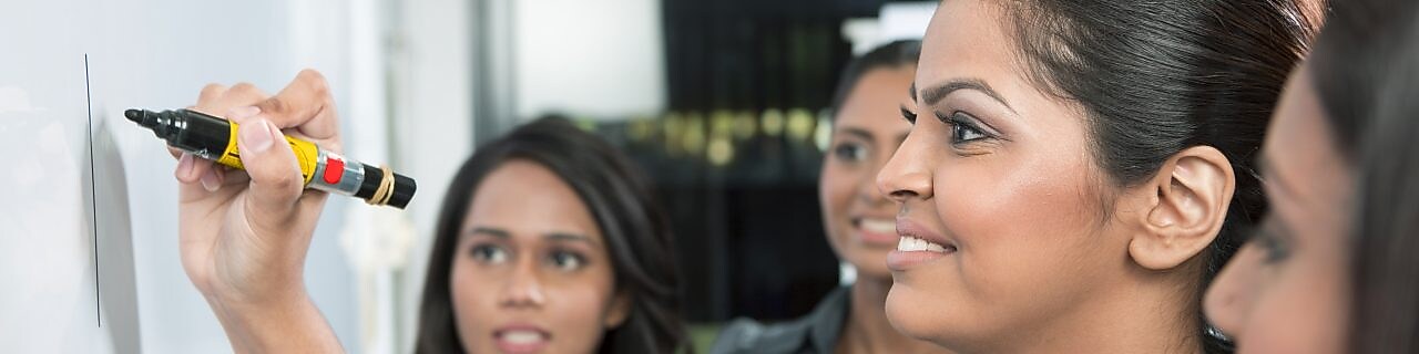 Bir iş lideri beyaz panoya yazı yazıyor