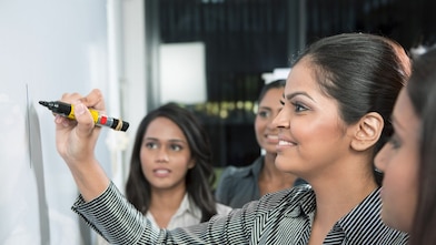 Bir iş lideri beyaz panoya yazı yazıyor