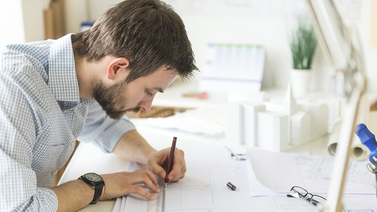 kağıda bir şeyler çizen genç bir mimar