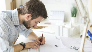 kağıda bir şeyler çizen genç bir mimar