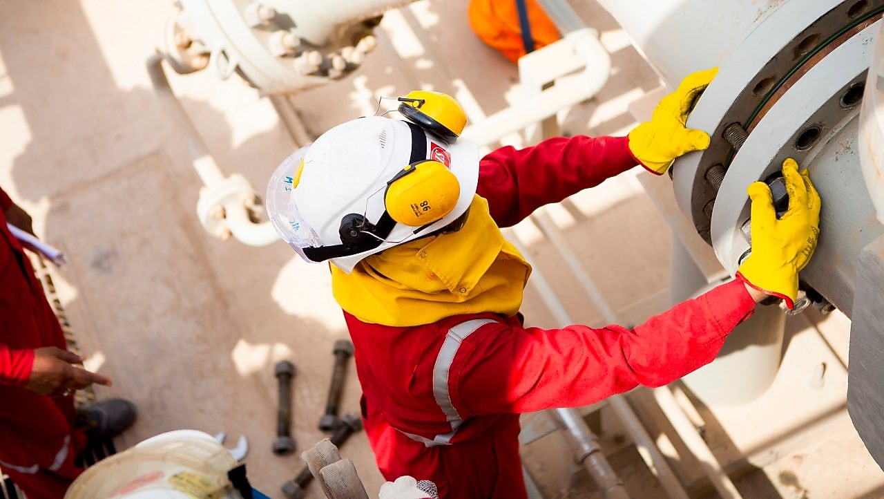 Güvenlik maskesi ve eldiven takan işçi
