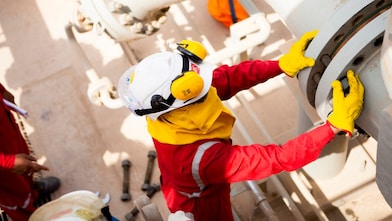 Güvenlik maskesi ve eldiven takan işçi