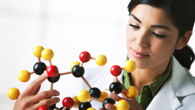 molekül modeline bakan bir bilim insanı