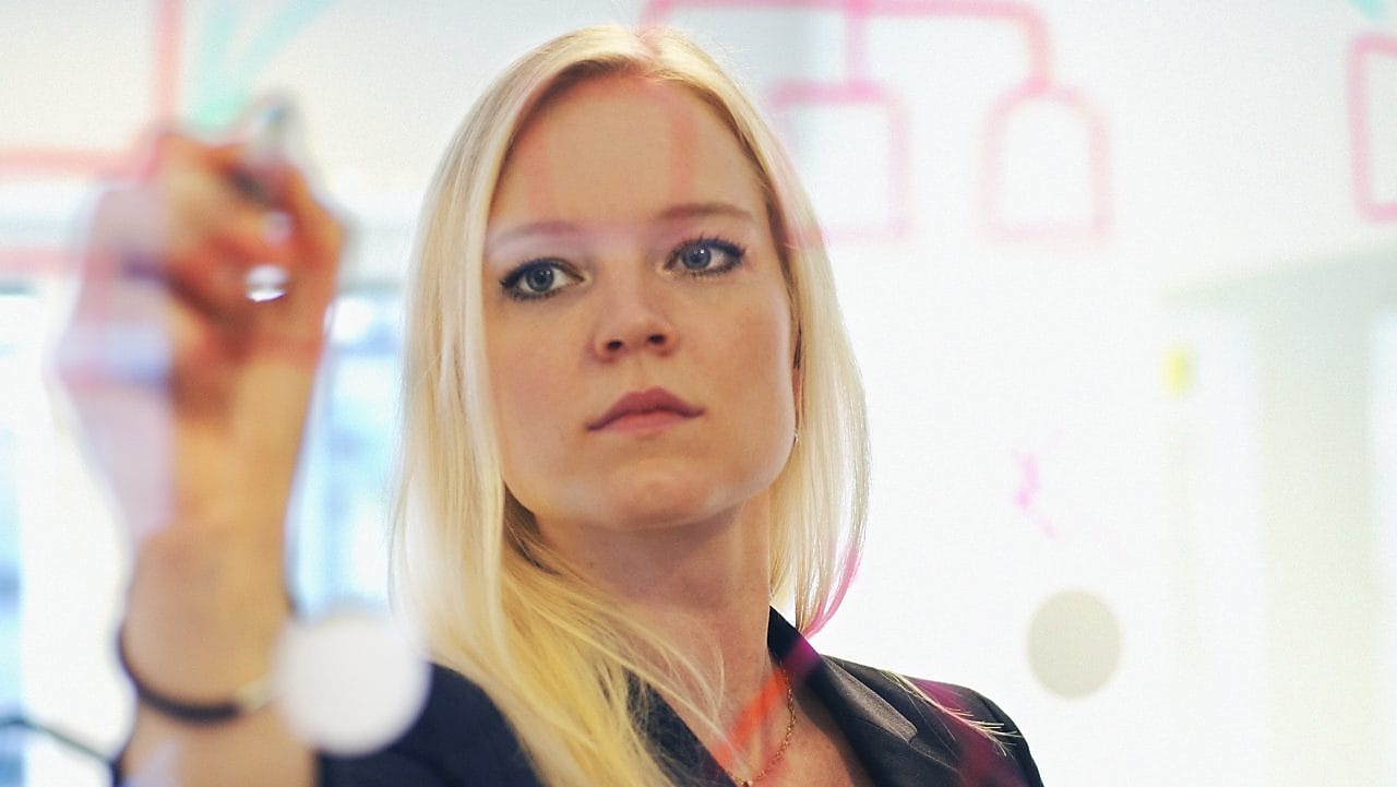 İsveç, ofisindeki cam duvara yazı yazan iş kadını