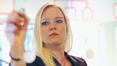 İsveç, ofisindeki cam duvara yazı yazan iş kadını