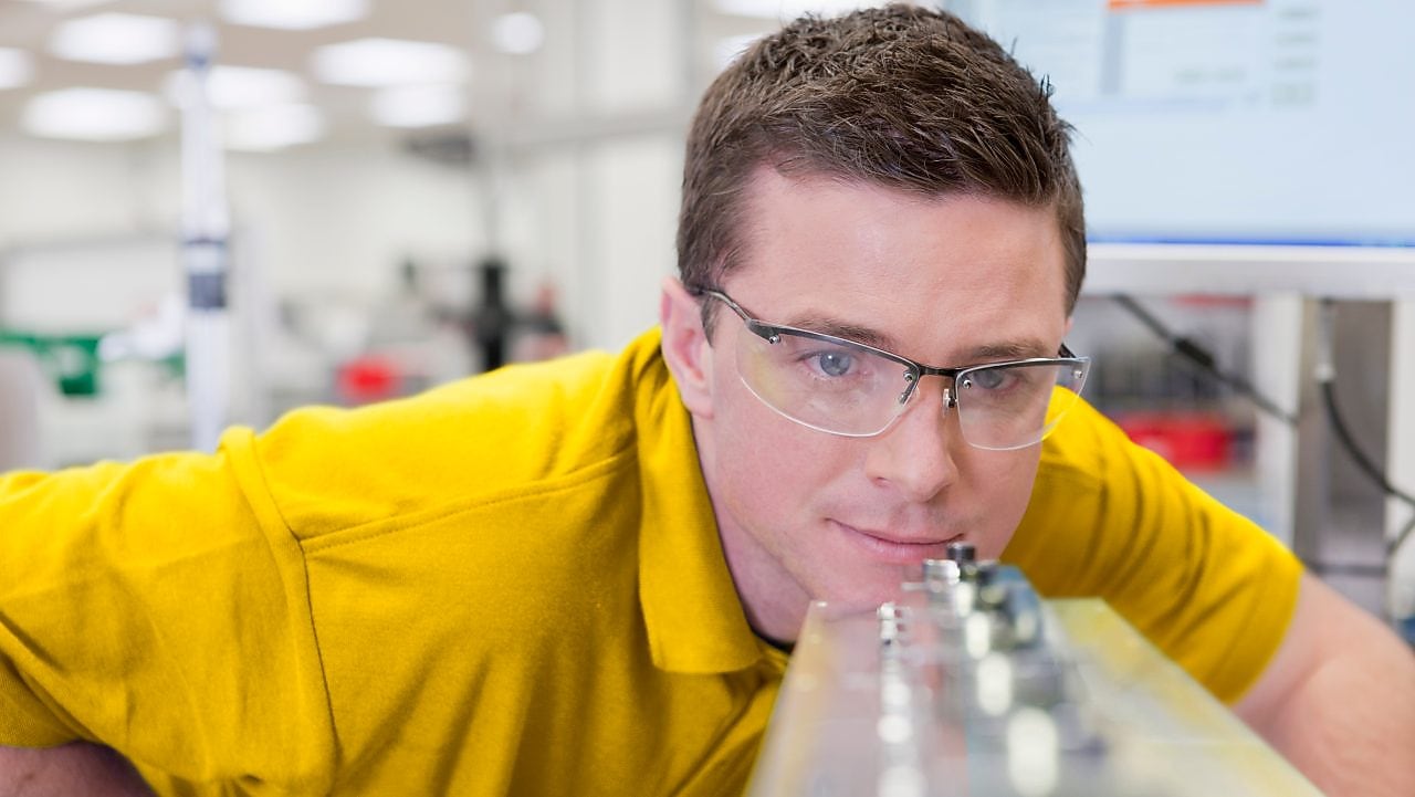 Laboratuarda bir cihaza bakan adam